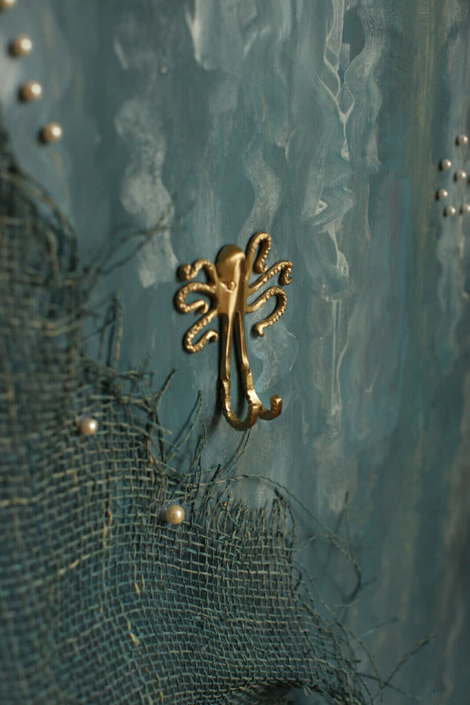 Gouden octopus hanger met twee haakjes.